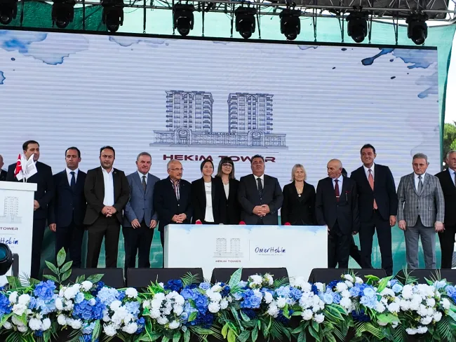Temel atma töreninde protokol; arkalarındaki dev ekranda Hekim Tower'ın mimari çizimi