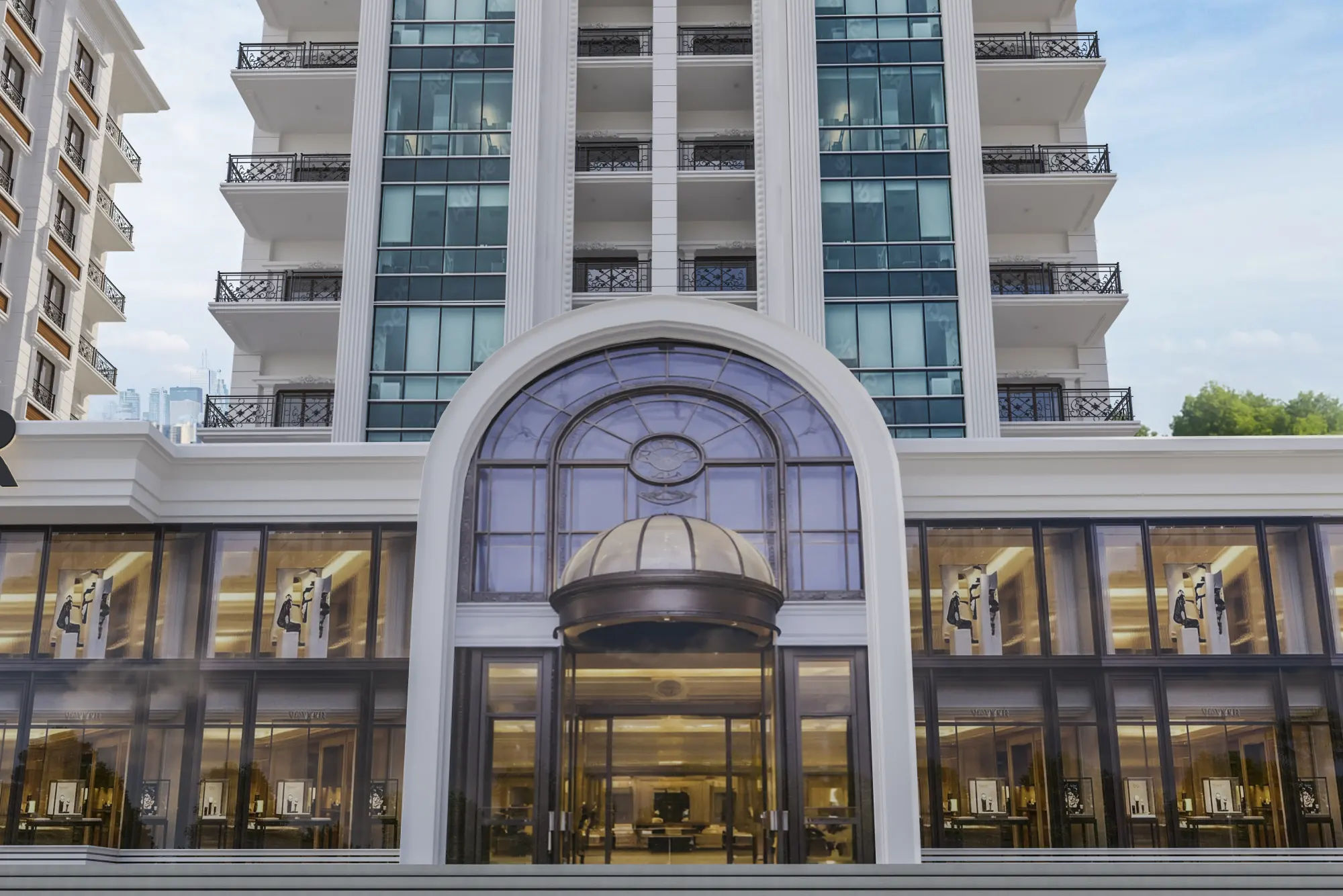 Hekim Tower ana girişi: kemerli cam cephe ve aydınlatılmış zemin kat vitrinleri