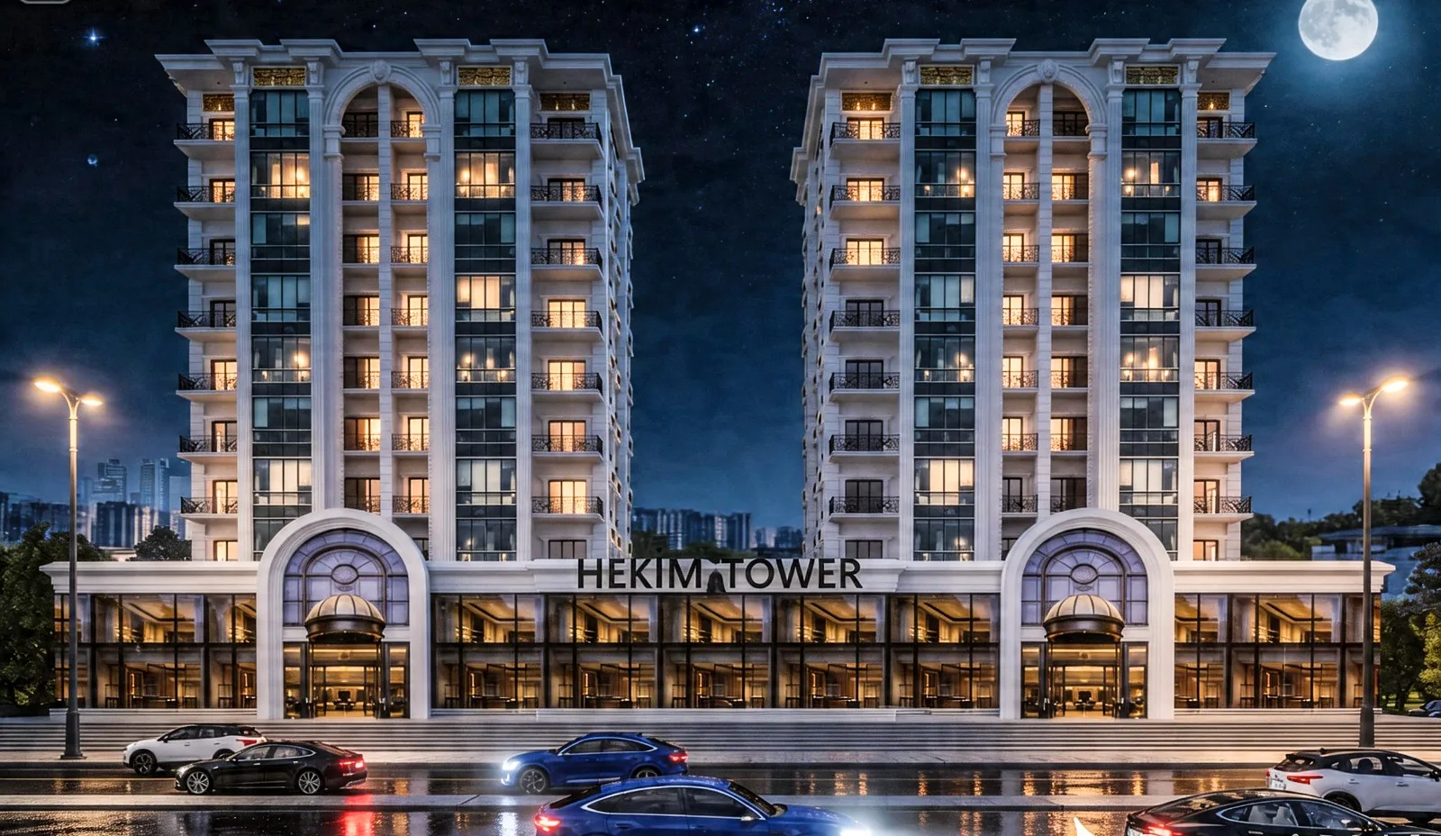 Hekim Tower'ın gece panoramik cephe görünümü: aydınlatılmış iki blok, iki kemerli giriş ve zemin kattaki cam vitrinler